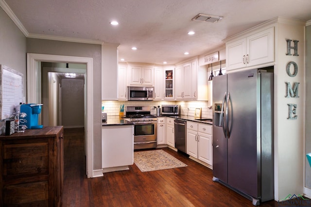 kitchen featuring backsplash, white cabinets, stainless steel appliances, and dark hardwood / wood-style floors