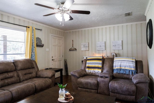 living room with hardwood / wood-style flooring, ceiling fan, crown molding, and a textured ceiling