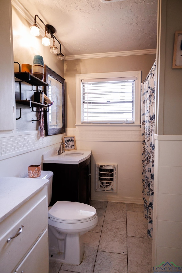 bathroom featuring heating unit, plenty of natural light, vanity, and a textured ceiling