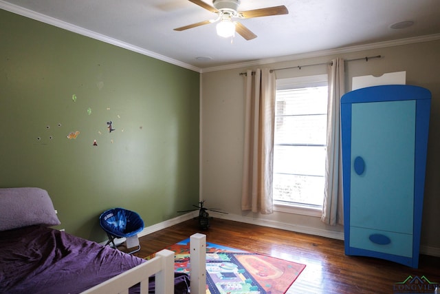 bedroom featuring ceiling fan, dark hardwood / wood-style flooring, ornamental molding, and multiple windows