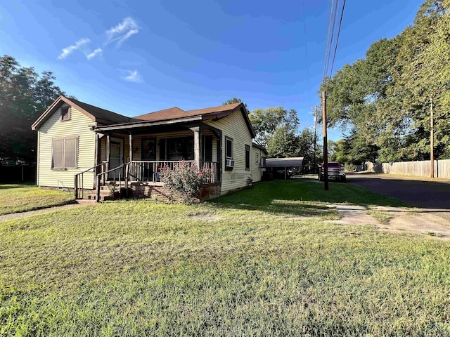 view of side of home with a lawn and covered porch