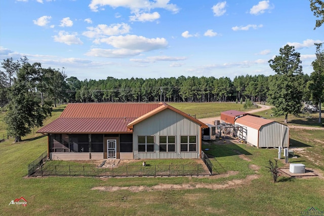 rear view of property featuring an outdoor structure and a yard