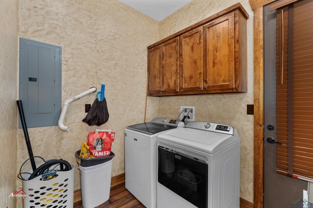 laundry area featuring washing machine and clothes dryer, electric panel, dark wood-type flooring, and cabinets