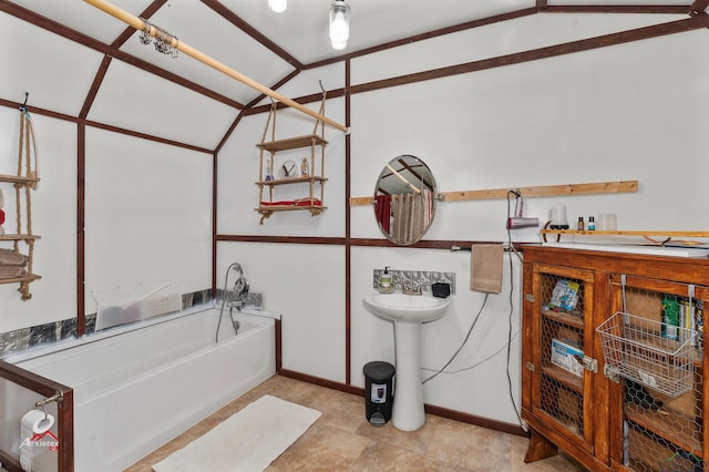 bathroom with a washtub and vaulted ceiling