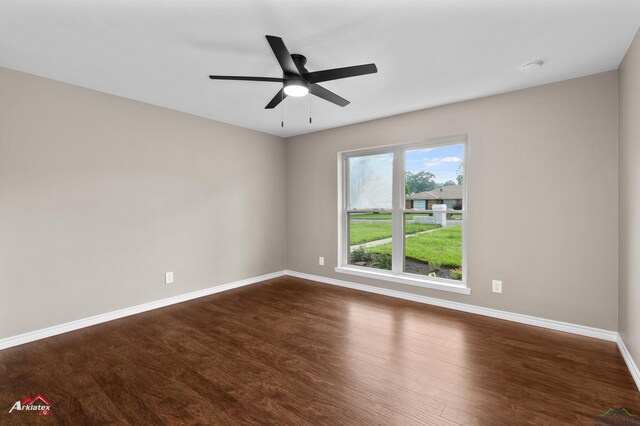 404 Pinewood, Marshall, TX 75672 - spare room featuring dark wood-style flooring, ceiling fan, and a smoke detector