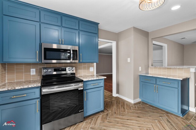 404 Pinewood, Marshall, TX 75672 - kitchen with appliances with stainless steel finishes, blue cabinetry, decorative backsplash, light stone counters, and recessed lighting