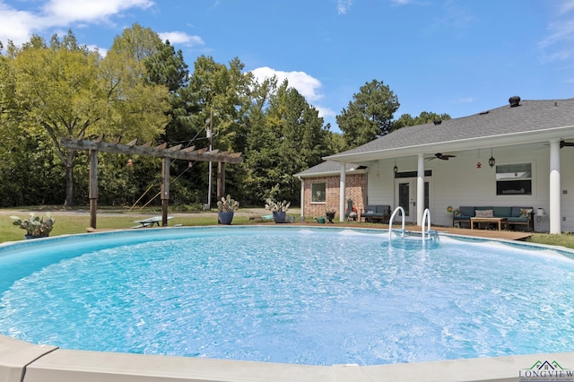 view of swimming pool featuring outdoor lounge area, ceiling fan, and a pergola