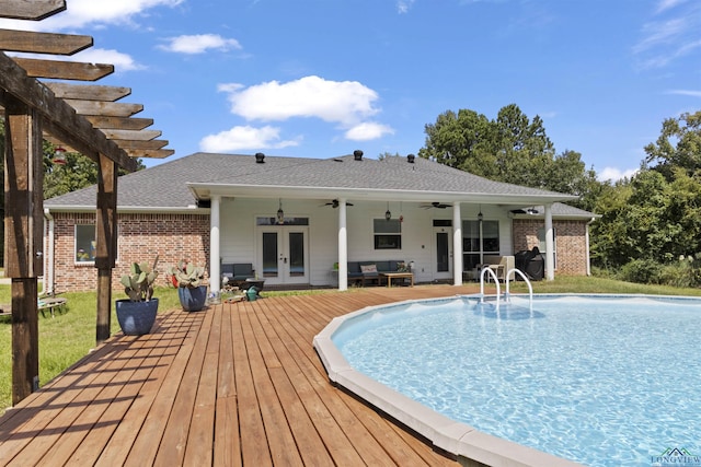 view of swimming pool featuring french doors, a pergola, a deck, and ceiling fan