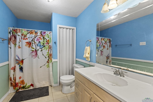 bathroom featuring vanity, tile patterned flooring, a shower with shower curtain, toilet, and a textured ceiling