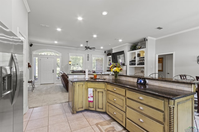 kitchen with light carpet, stainless steel refrigerator with ice dispenser, ceiling fan, and dark stone counters