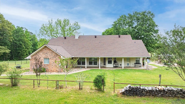 back of property with a yard and a patio area