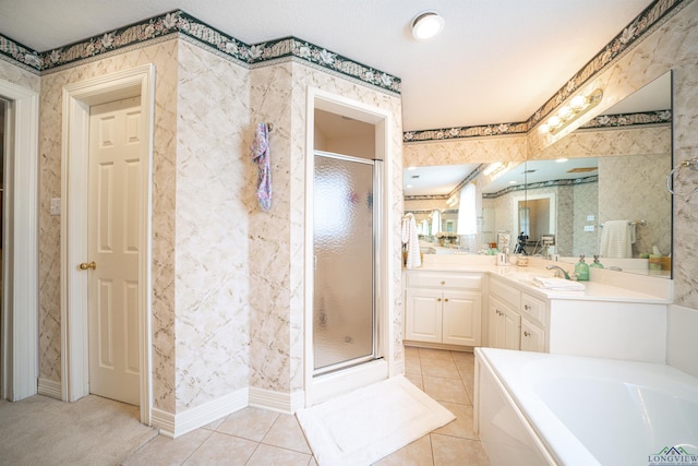 bathroom with a textured ceiling, separate shower and tub, tile patterned floors, and vanity