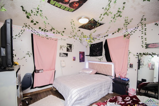 bedroom featuring a textured ceiling and wood finished floors