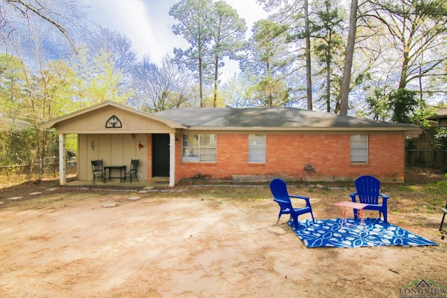 back of property with brick siding and a patio
