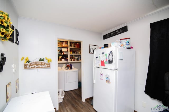 kitchen featuring washing machine and clothes dryer, dark wood-style floors, and freestanding refrigerator