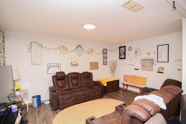 living area featuring wood finished floors, visible vents, and baseboards