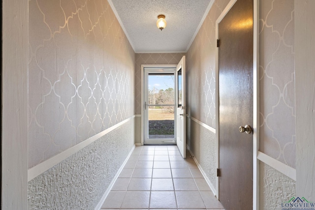 doorway to outside with light tile patterned floors and crown molding