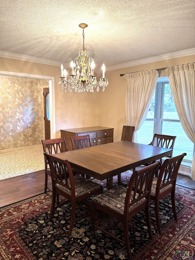 dining area with a chandelier, a textured ceiling, and ornamental molding