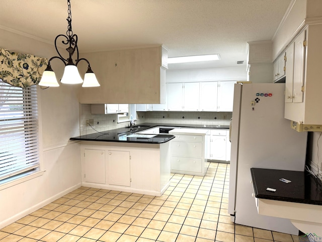 kitchen featuring pendant lighting, sink, kitchen peninsula, a notable chandelier, and white cabinetry