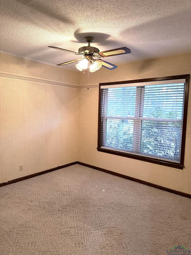 carpeted spare room with a textured ceiling and ceiling fan