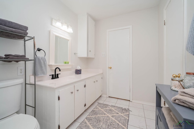 bathroom with tile patterned flooring, vanity, and toilet