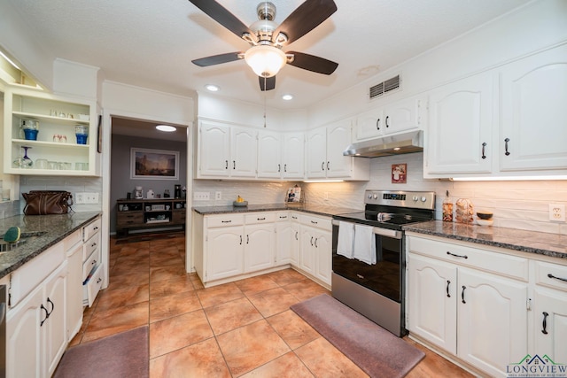 kitchen featuring stainless steel electric range, backsplash, dark stone counters, white cabinets, and light tile patterned flooring