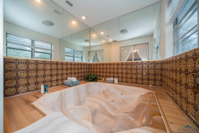 bathroom with hardwood / wood-style floors and a bath