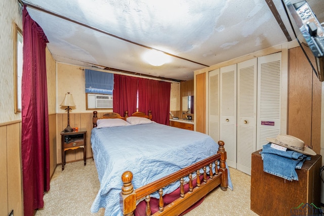 carpeted bedroom featuring a closet, cooling unit, and wood walls