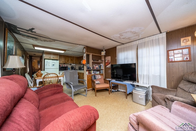 living room featuring wooden walls and light carpet