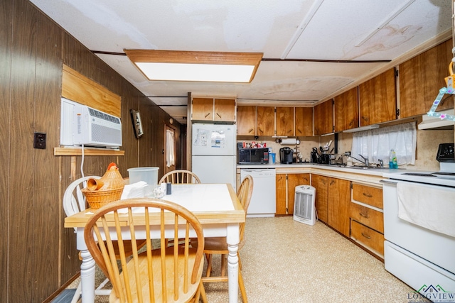 kitchen with sink, white appliances, range hood, and wood walls