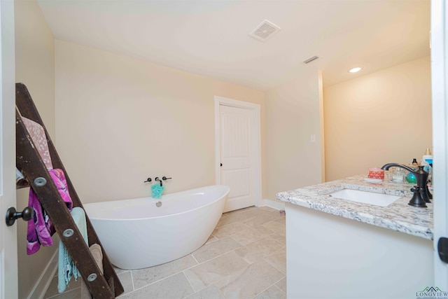 full bath with a freestanding tub, baseboards, vanity, and recessed lighting
