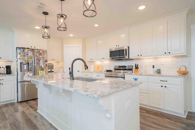 kitchen with appliances with stainless steel finishes, a sink, dark wood-type flooring, backsplash, and recessed lighting