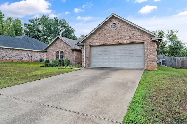 view of front of home featuring a garage, a front yard, and central air condition unit