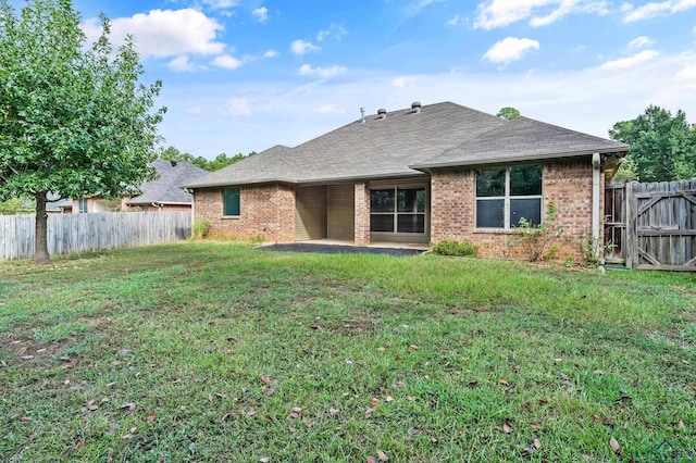 back of house featuring a patio and a lawn