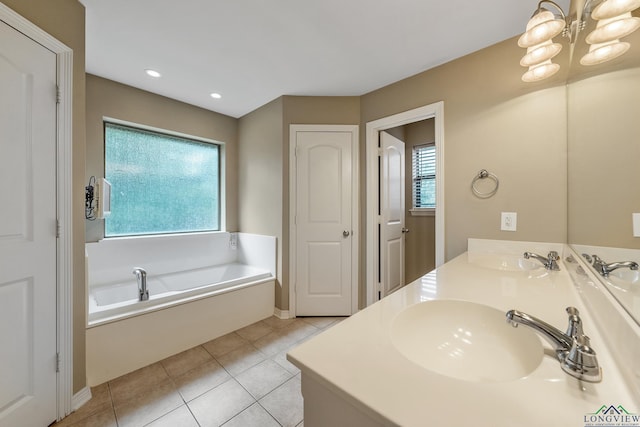 bathroom with tile patterned flooring, a bath, vanity, and an inviting chandelier