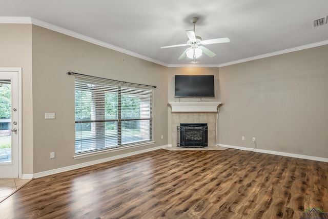 unfurnished living room featuring a healthy amount of sunlight, a tiled fireplace, and hardwood / wood-style floors