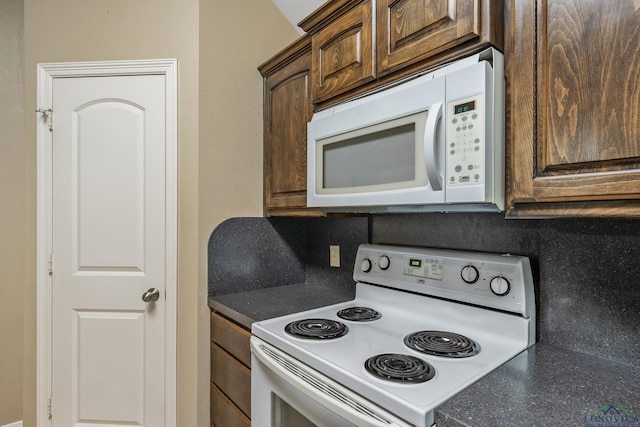 kitchen with dark brown cabinetry and white appliances