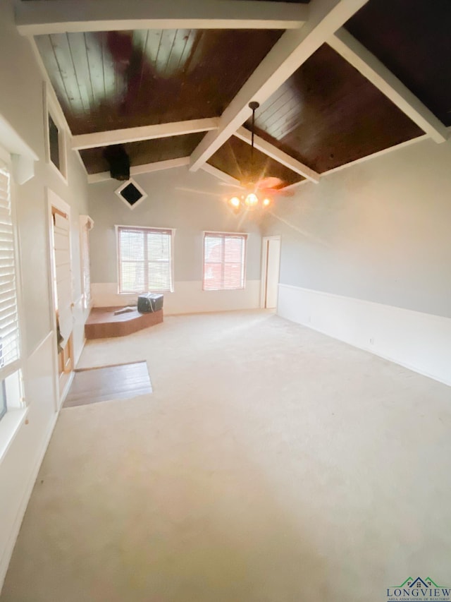 empty room with carpet flooring, lofted ceiling with beams, ceiling fan, and wooden ceiling