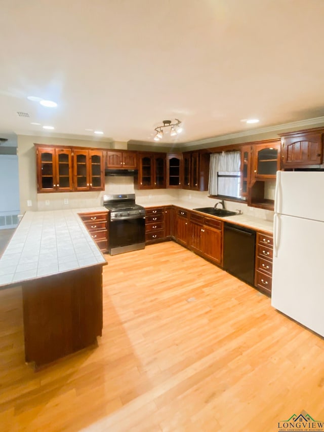 kitchen with sink, black dishwasher, stainless steel range with gas cooktop, white refrigerator, and light hardwood / wood-style floors