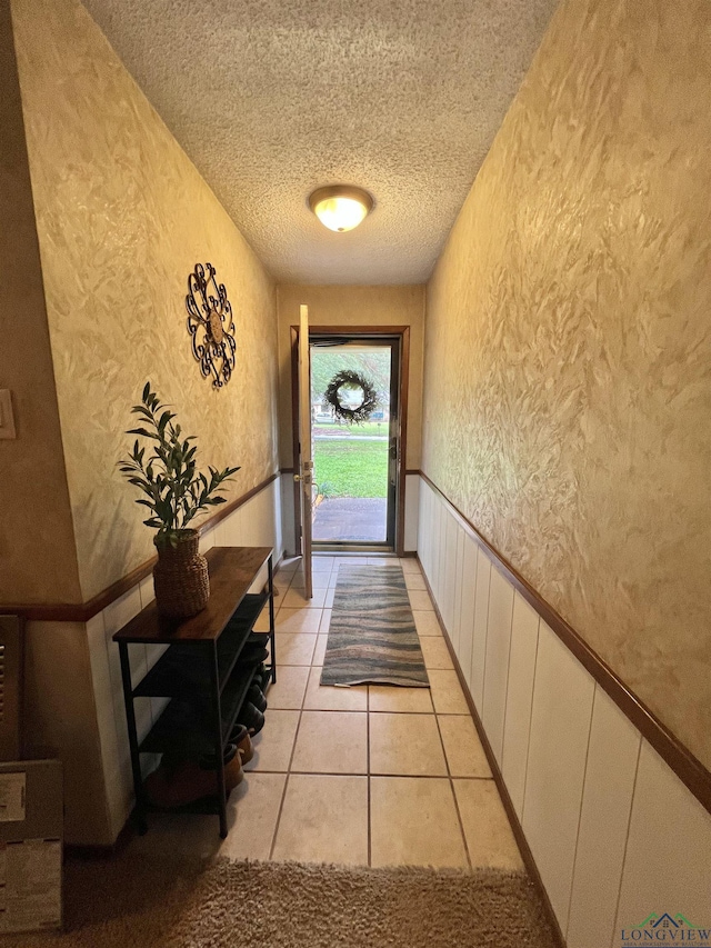 406 Campbell St, Daingerfield, TX 75638 - entryway with a wainscoted wall, a textured ceiling, a textured wall, and light tile patterned floors