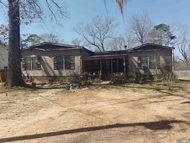 back of house featuring fence and dirt driveway