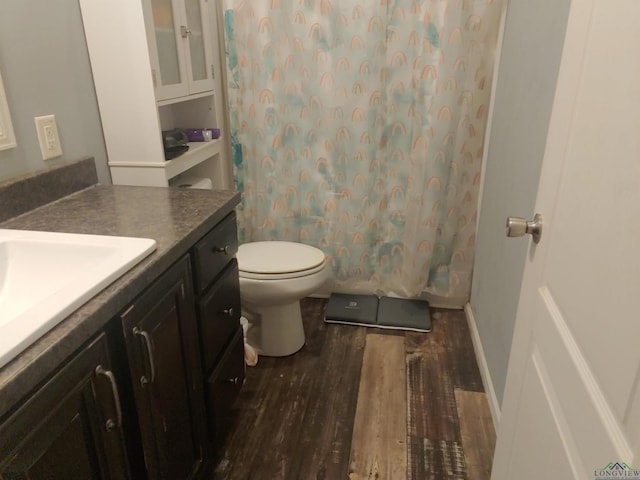 full bath featuring baseboards, toilet, wood finished floors, and vanity