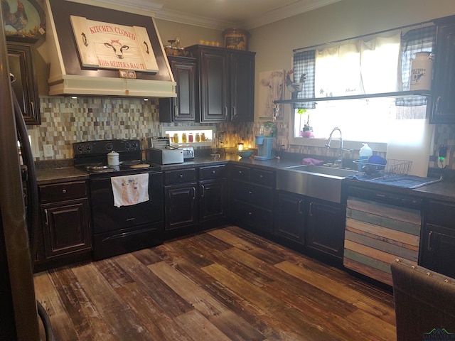 kitchen with custom range hood, dark countertops, black range with electric cooktop, dark wood finished floors, and crown molding