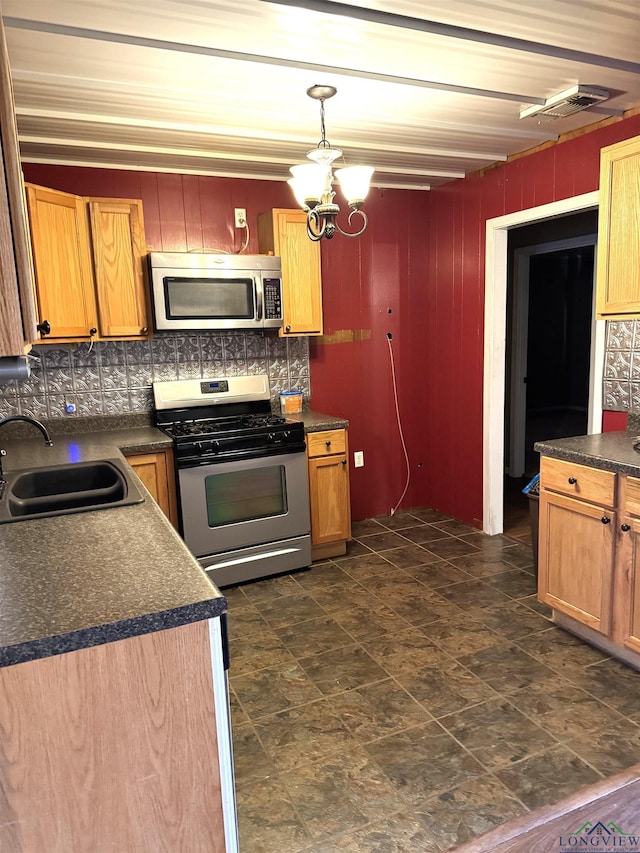 kitchen with appliances with stainless steel finishes, backsplash, sink, a notable chandelier, and hanging light fixtures