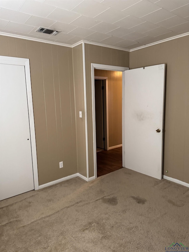 carpeted empty room featuring crown molding