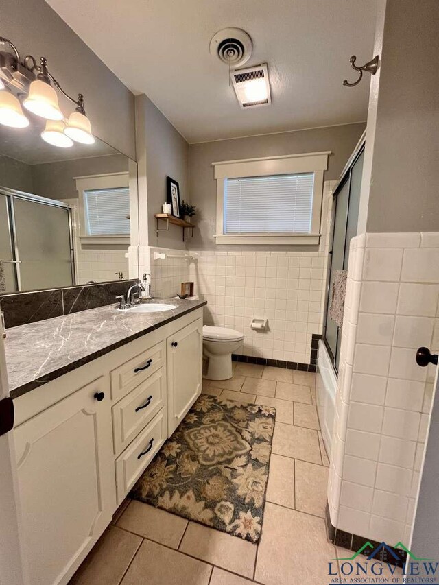 16 Pegues Pl, Longview, TX 75601 - full bathroom featuring tile walls, tile patterned flooring, vanity, and wainscoting