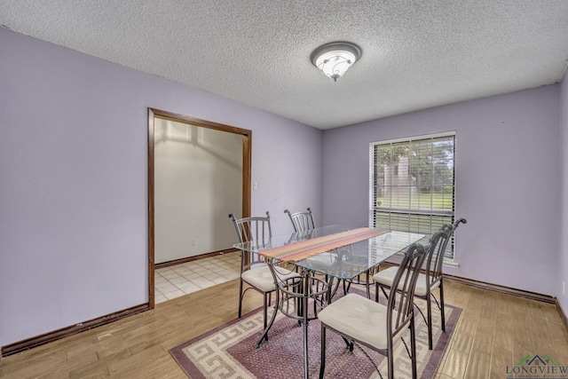 2202 Woodbine Dr, Gladewater, TX 75647 - dining area with a textured ceiling and light wood-style floors