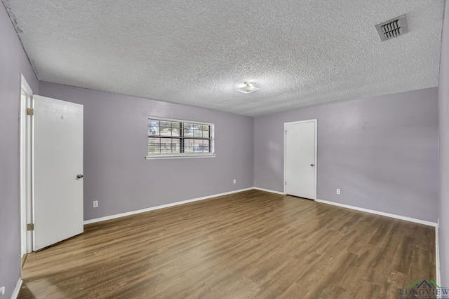2202 Woodbine Dr, Gladewater, TX 75647 - spare room featuring wood finished floors and a textured ceiling