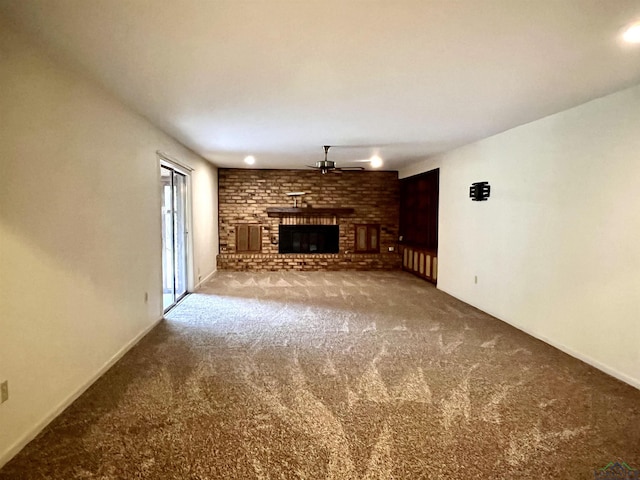 unfurnished living room with carpet, ceiling fan, and a brick fireplace