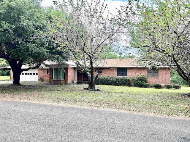 ranch-style house with a garage and a front lawn